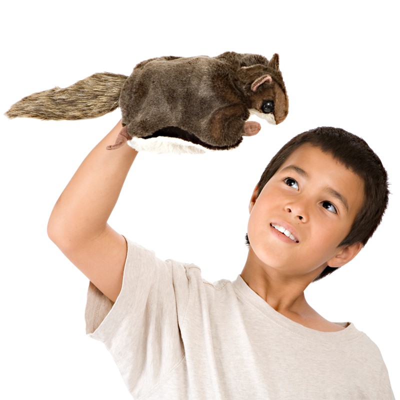 Junge hält Folkmanis Handpuppe Flughörnchen mit braunem Fell und buschigem Schwanz hoch über seinen Kopf