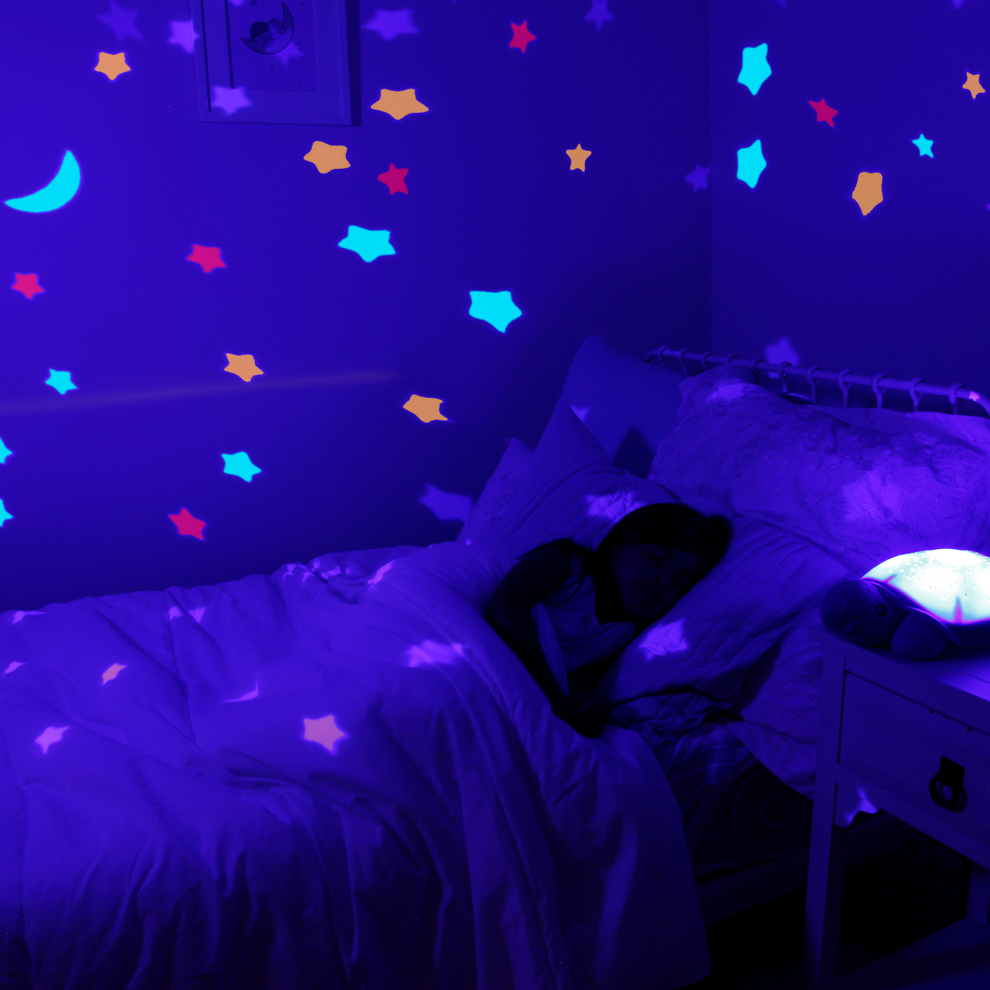 Cloud b Einschlafhilfe Twinkling Twilight Turtle Pink, Anwendungsfoto mit bunter Sternenprojektion im dunklen Zimmer