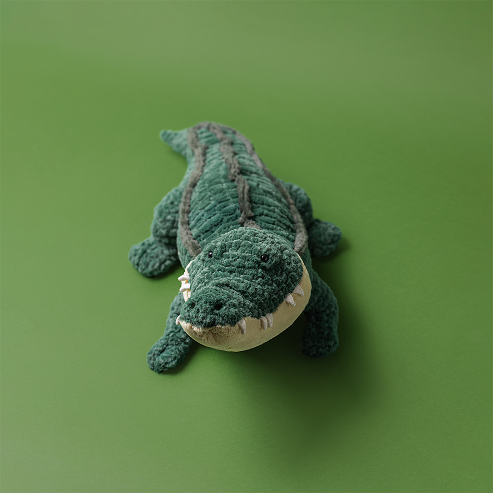 Jellycat Kuscheltier Alligator Allexi, Aufsicht auf grünes geripptes Rückenfell mit hellem Rücken vor grünem Hintergrund