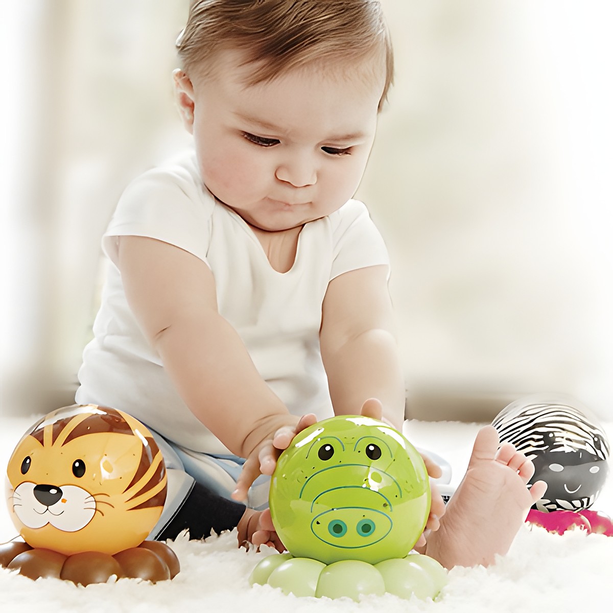 Cloud b sleep aid Dreamz to Go, lifestyle photo of baby playing with tiger, crocodile and zebra night lights