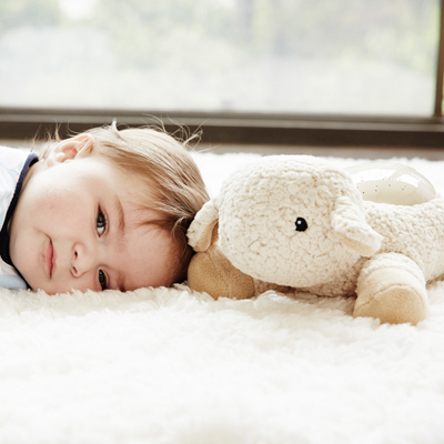Cloud b sleep aid Twilight Buddies rabbit, lifestyle photo with toddler lying next to the plush toy