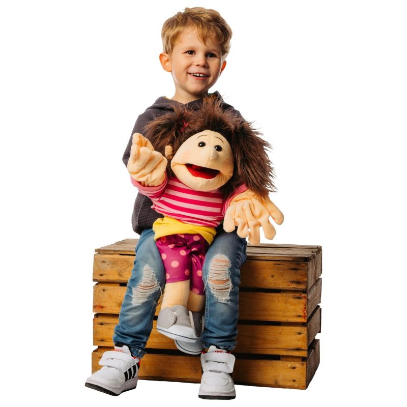 Junge sitzt auf einer Holzkiste und spielt die Living-Puppets-Handpuppe Finja auf seinem Schoß